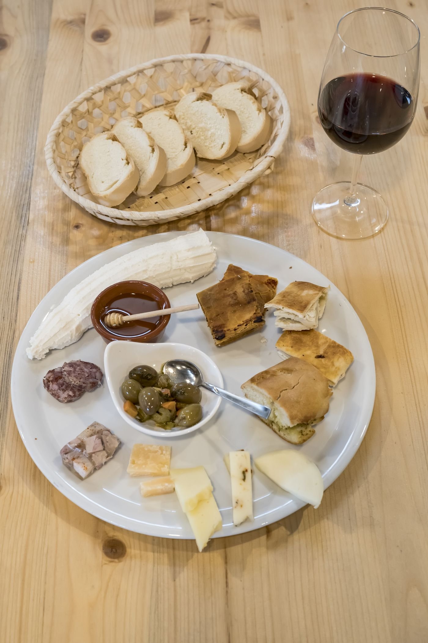 Tagliere di formaggi, ricotta, olive e vino rosso